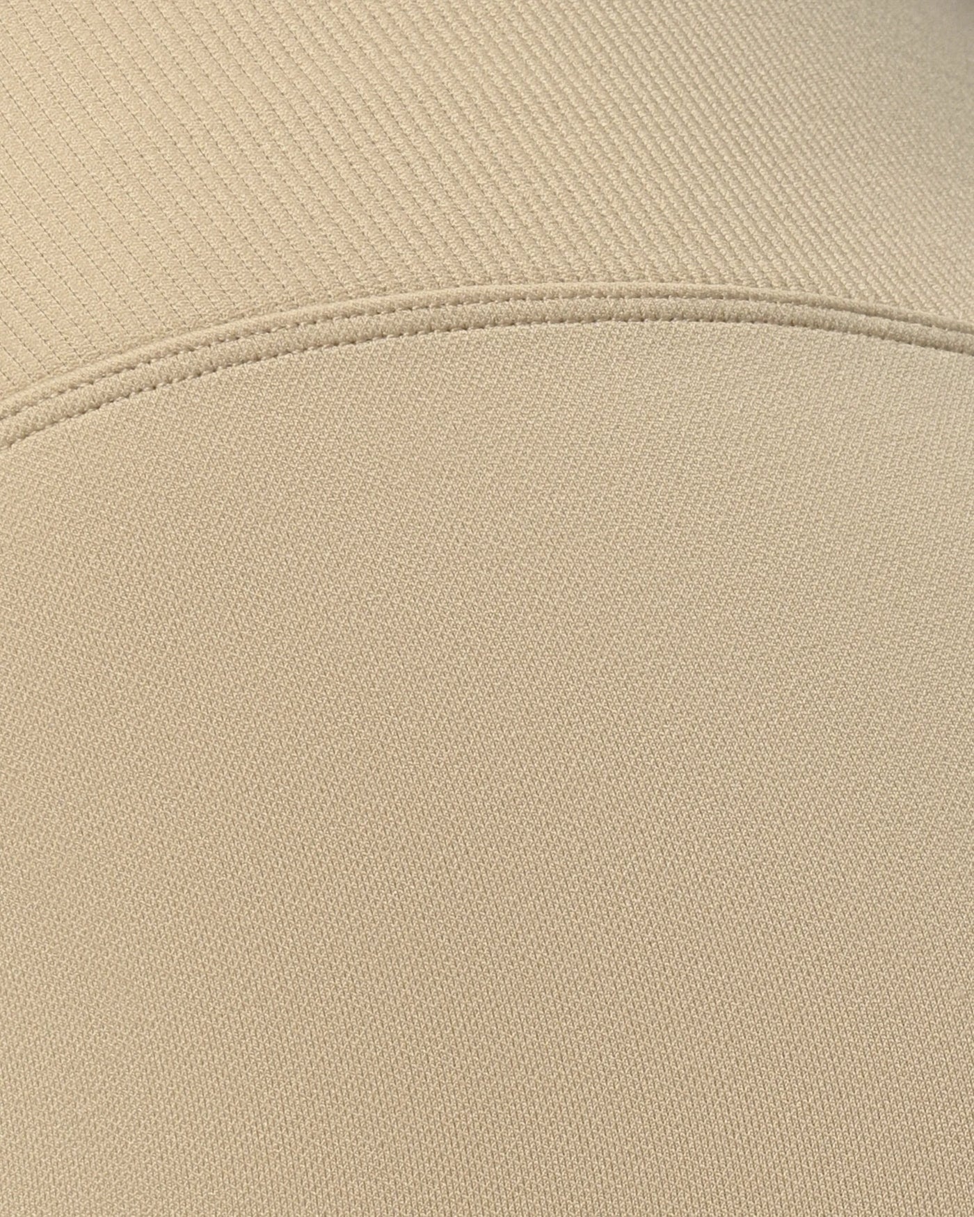 Close-up of beige fabric with a visible seam %Cream%