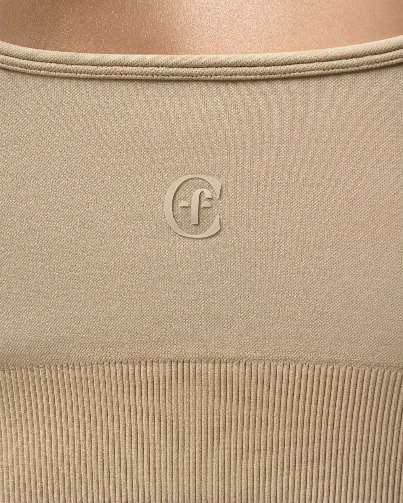 Close-up of beige fabric with a logo on a light brown background %Cream%